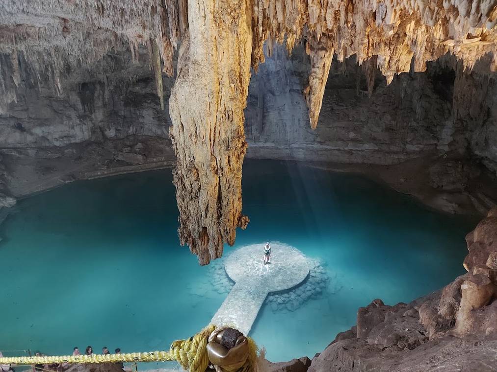 Cenote Suytun con su plataforma circular y el haz de luz iluminando el interior
