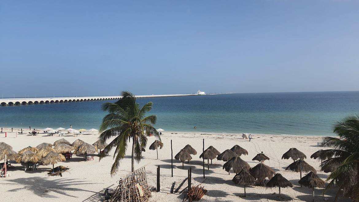 Playa de Progreso con palapas y el muelle al fondo, Yucatán